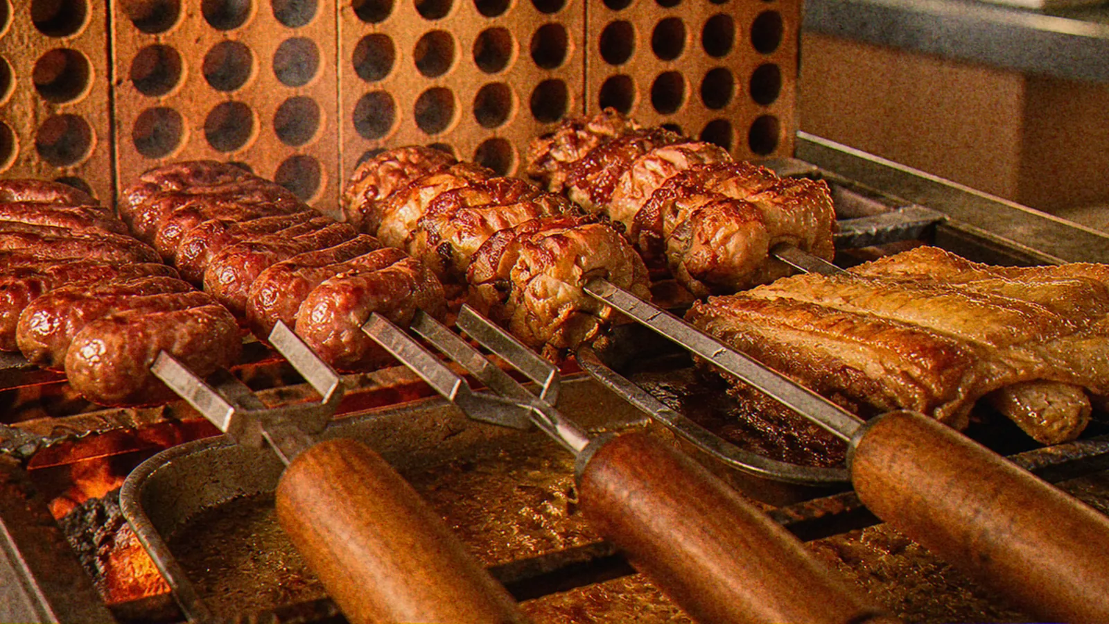 Churrasqueira a carvão do Ponto Certo com linguiça, frango com bacon e costela na grelha